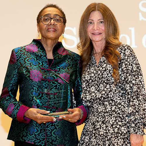 Dr. Reneida Reyes holding a plaque, alongside Dr. Stacy Reisfeld